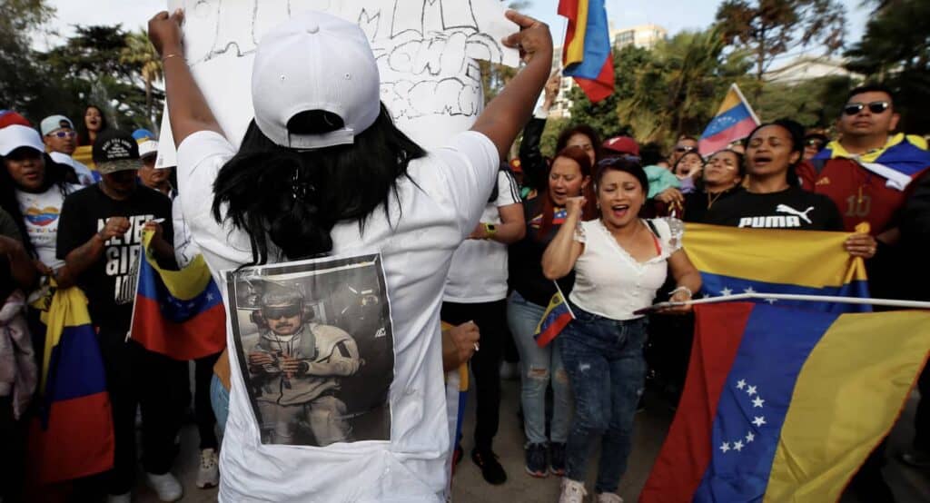 Manifestants vénézuéliens protestant contre Maduro avec drapeaux et slogans.