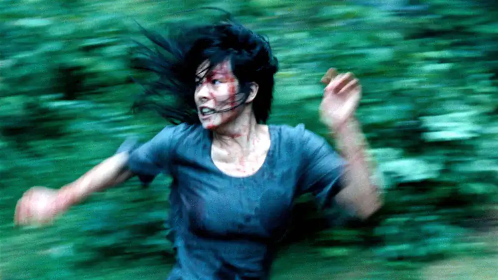 Femme en mouvement rapide dans la forêt, illustrant la violence et le chaos liés à la thématique d'E.