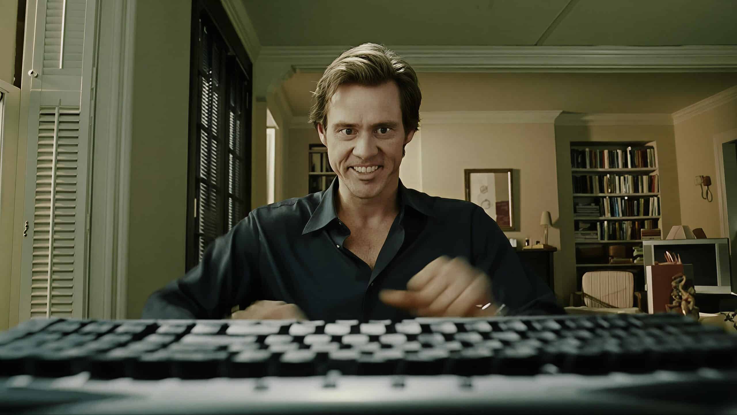 Homme souriant devant un clavier d'ordinateur