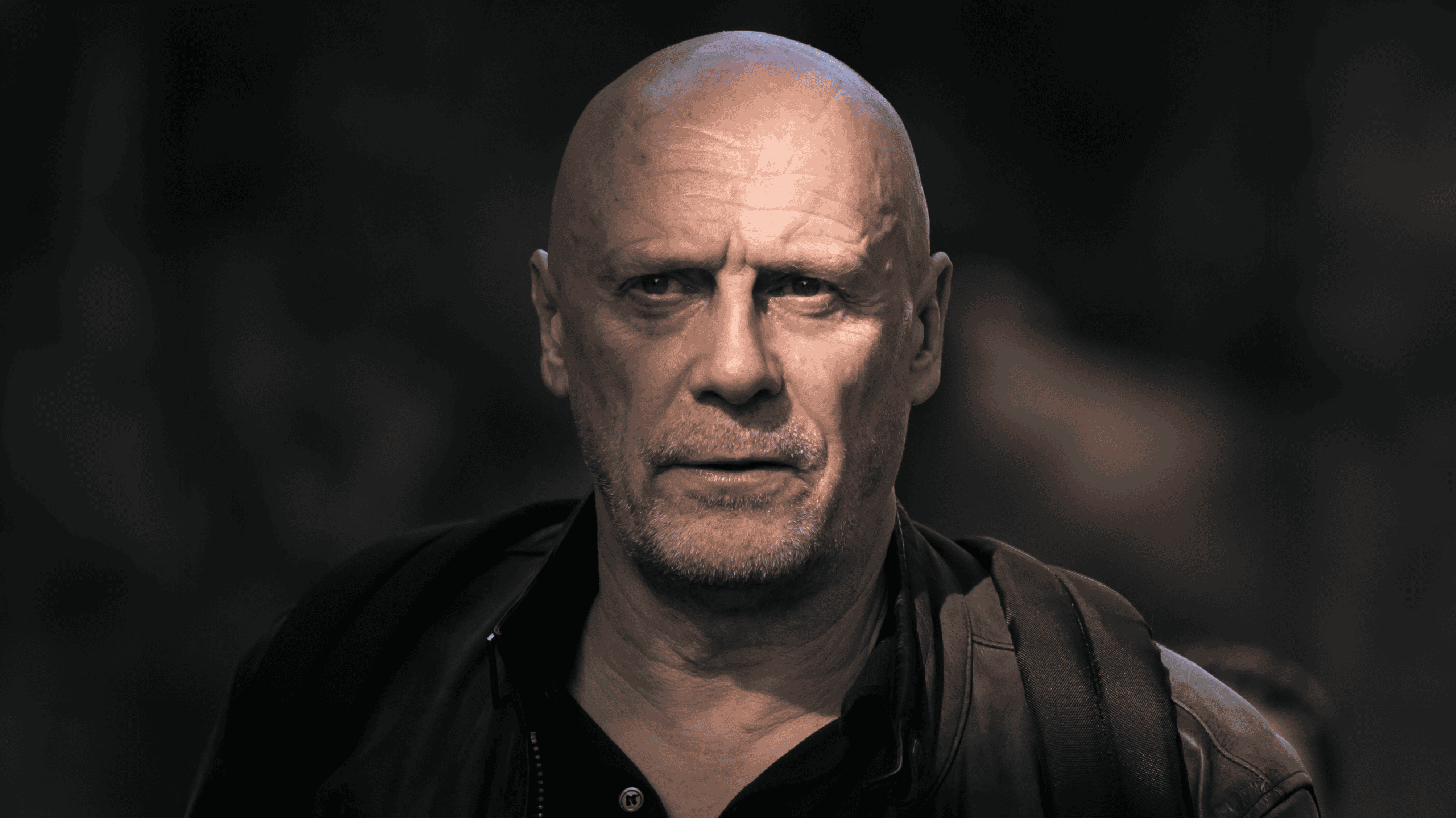 Portrait rapproché d’un homme chauve au regard intense