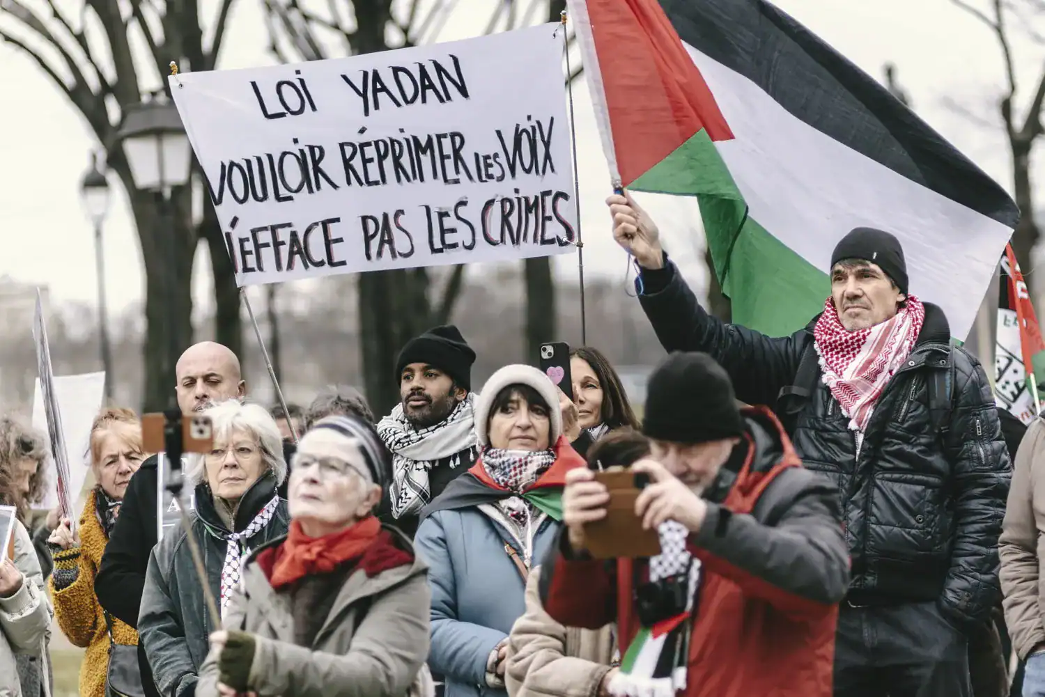 Manifestation avec drapeau palestinien et pancarte contestataire