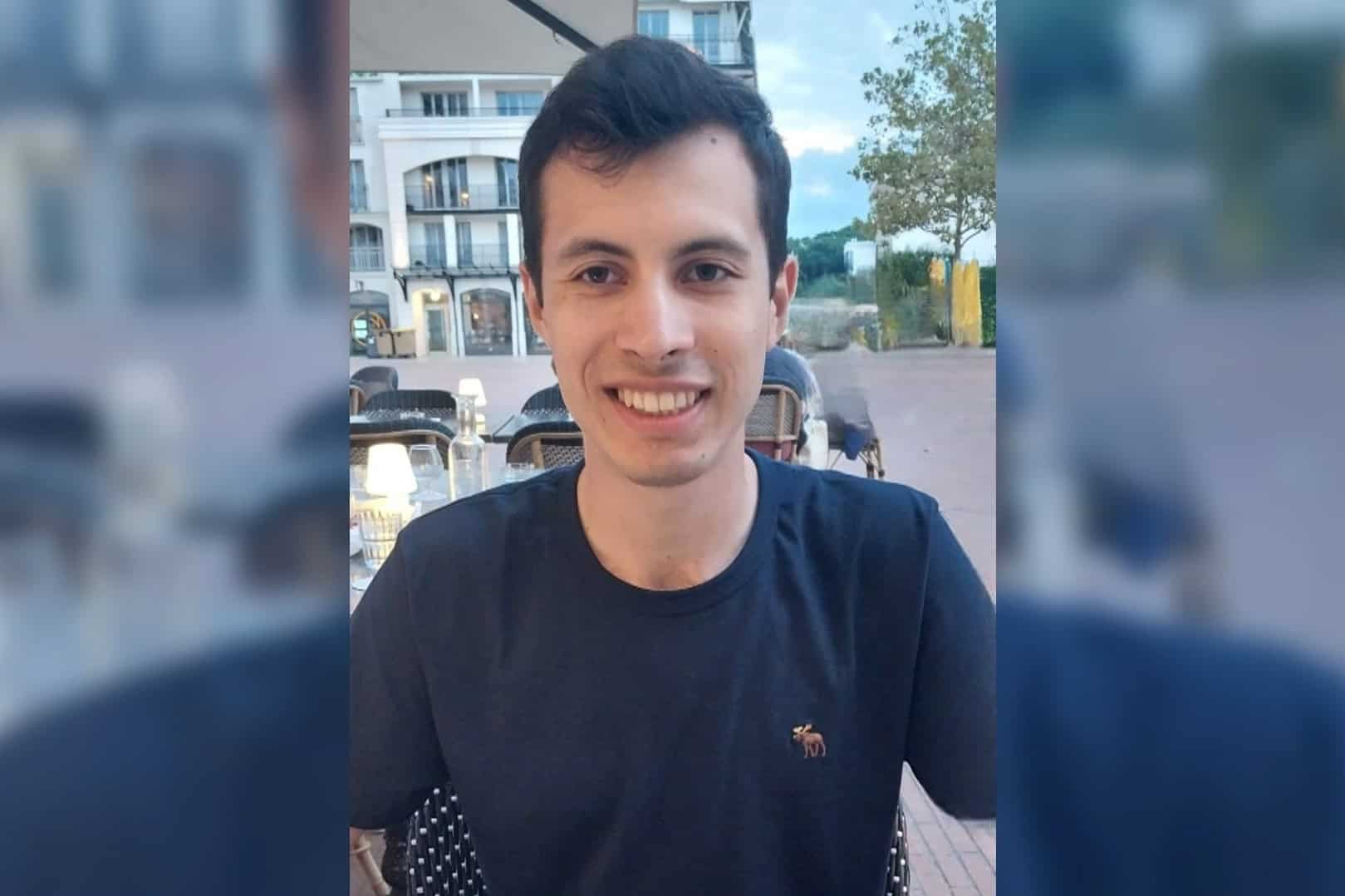 Homme souriant assis à une terrasse